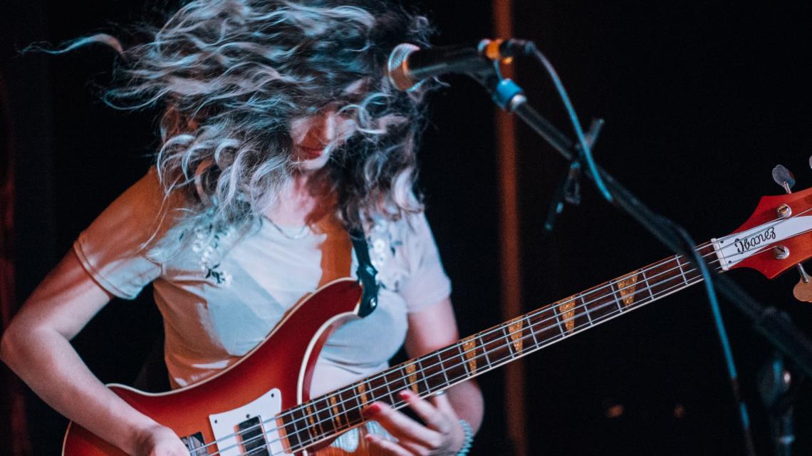 Someone playing the bass guitar